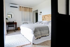 um quarto branco com uma cama e uma secretária em U San Daniellu villas et chambres em Farinole