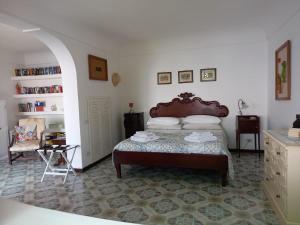 a bedroom with a bed and a chair in it at Casa Reverie - Amalfi Coast in Praiano