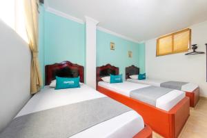 2 camas en una habitación con paredes azules en Ayenda La Terraza Popayán en Popayán