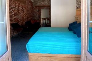 een slaapkamer met een groot blauw bed in een kamer bij 109 SUITES DONCELES C/BALCON CENTRO HISTÓRICO CDMX in Mexico-Stad
