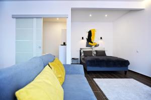 a living room with a blue couch and a bed at ZÓRA APARTMAN in Eger