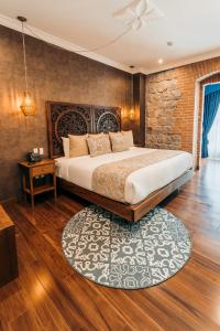 a bedroom with a large bed and a brick wall at Hotel Otavalo in Otavalo