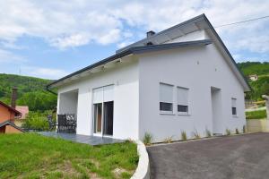 a white house with a driveway at Apartman RIO in Jajce