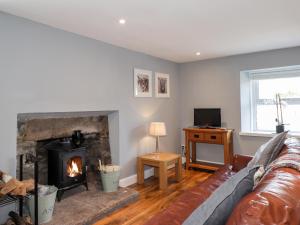 a living room with a couch and a fireplace at Livet Cottage in Tomintoul