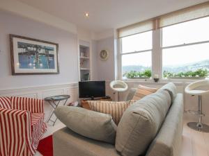 a living room with a couch and a tv at Flat 1, 32 Newcomen Road in Dartmouth