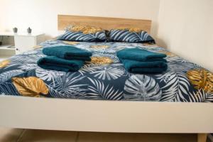 Una cama con mantas azules y almohadas. en studio cosy TV WIFI confortable et chaleureux en Gaillon