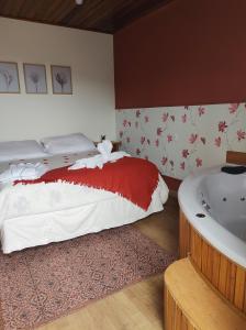 1 dormitorio con cama y bañera en Pousada Miraggio, en Campos do Jordão