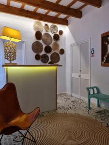 um quarto com uma cadeira e uma parede com pratos em Habitaciones Casa de Campo Daymipaz em Maó