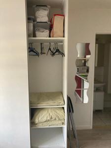 biała szafa z półkami i wieszakami w obiekcie Studio tout équipé au calme w mieście Cappelle-la-Grande