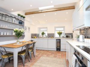 a kitchen with a table and chairs in a kitchen at Bwthyn Siliwen Old Bath House in Bangor