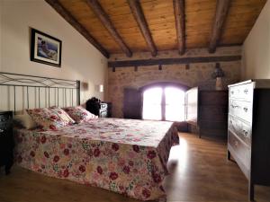 a bedroom with a bed and a dresser and a window at Casa Tropiet in Beceite