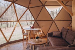 a room with a couch and a table in a yurt at VasaRojaus Kupolai in Birštonas