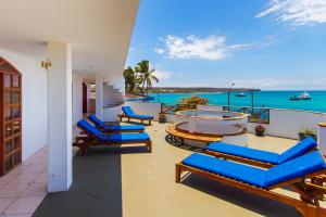 a balcony with blue lounge chairs and the ocean at Grand Hotel Leon Marino Galapagos in Puerto Ayora