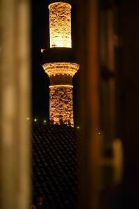 a tower lit up at night with lights on it at Tomor Shehu Guest House in Berat