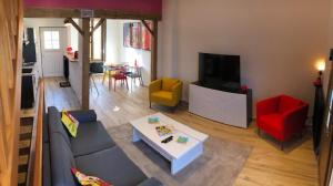 sala de estar con sofá y TV en Maison avec garage Pop' Appart', en Laon