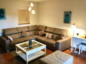 uma sala de estar com um sofá e uma mesa de centro em La casa del pantano de San Juan em San Martín de Valdeiglesias