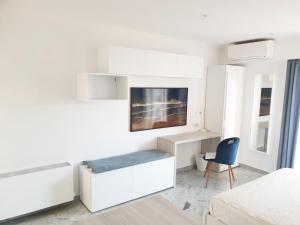 Habitación blanca con cama y escritorio. en Beautiful T1 with sea view en Niza