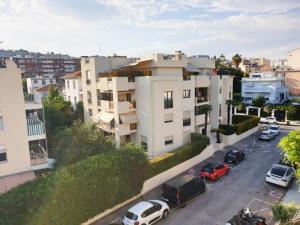 ein Apartmenthaus mit Autos auf einem Parkplatz in der Unterkunft Beautiful T1 with sea view in Nizza