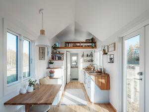 a kitchen with white cabinets and a wooden table at Camp Saltstraumen-Elvegård in Bodø