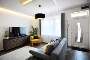 a living room with a couch and a tv at ZÓRA APARTMAN in Eger