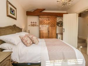 a bedroom with a white bed and a chandelier at The Old Post House in Grange Over Sands