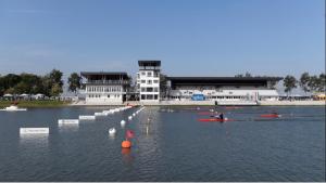 a group of people kayaking in a lake in front of a building at Dóm square-Centrum-Free Parking in Szeged