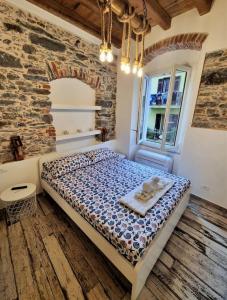 - une chambre avec un lit et un mur en briques dans l'établissement L' Onda di Manarola, à Manarola