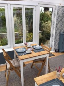 a table and chairs in a room with windows at Les Camelias in Binic