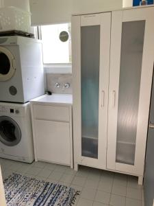 a kitchen with a sink and a washing machine at Jones Beach Haven Studio - Kiama Downs Beachside Escape in Kiama
