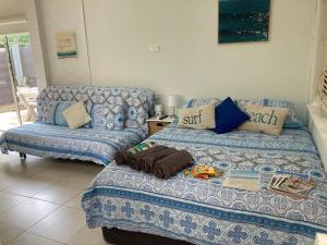 Jones Beach Haven Studio - Kiama Downs Beachside Escape في كياما: غرفة معيشة بها سريرين وأريكة