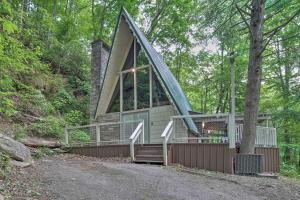 a cabin in the woods with a tree at A-Frame Gatlinburg Cabin with Deck and Private Hot Tub in Gatlinburg