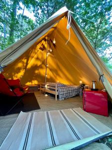 Zelt mit einem Bett und einem Tisch in der Unterkunft Tente Indiana Chênes - La Téouleyre in Saint-Julien-en-Born
