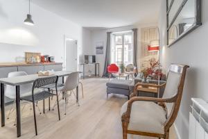 a dining room and living room with a table and chairs at 32CaL QuEROL Boutique Puigmal in Puigcerdà