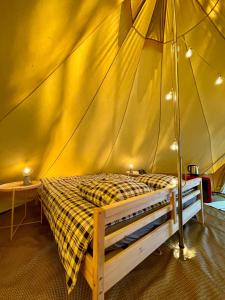1 dormitorio con 1 cama en una tienda de campaña en Tente Indiana Chênes - La Téouleyre en Saint-Julien-en-Born