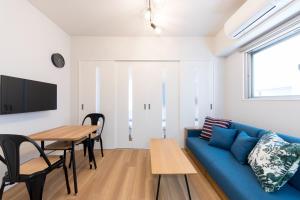 ein Wohnzimmer mit einem blauen Sofa und einem Tisch in der Unterkunft SG RESIDENCE INN HAKATA - Vacation STAY 61970v in Fukuoka