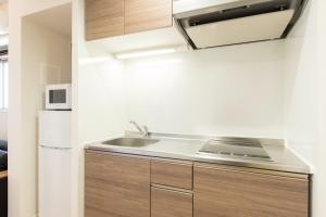 eine Küche mit einer Spüle und einem Kühlschrank in der Unterkunft SG RESIDENCE INN HAKATA - Vacation STAY 61970v in Fukuoka