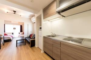 a kitchen with a sink and a living room at SG RESIDENCE INN HAKATA - Vacation STAY 61970v in Fukuoka