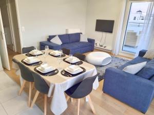 a living room with a table and a blue couch at BELQUIS in Chessy