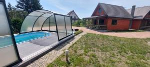 una imagen de una piscina con una casa de cristal en Siesta Country en Świebodzin
