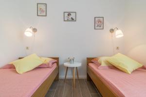 two beds in a room with a table and two lamps at Apartments Punta in Kruševo