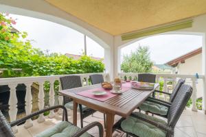 a wooden table on a balcony with chairs at Apartments Punta in Kruševo