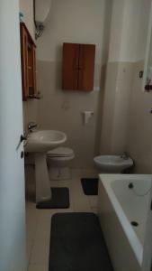 a bathroom with a sink and a toilet and a tub at Appartamento luminoso, semplice con ogni comfort in Lido di Ostia