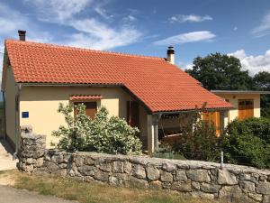 une maison avec un toit orange et un mur en pierre dans l'établissement Holiday house Green Dream, à Obrovac