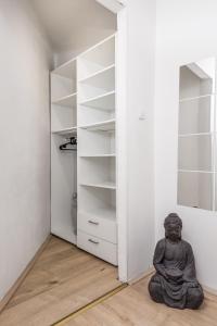 a buddha statue sitting on the floor in front of a closet at Lena in Rijeka