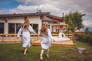 two girls are walking in front of a bed at Hotel San Giacomo Spa&Gourmet in Brentonico