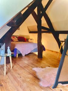 Zimmer im Dachgeschoss mit einem Bett und einem Tisch in der Unterkunft Villa SAINT CHRISTOPHE de FIRFOL in Firfol