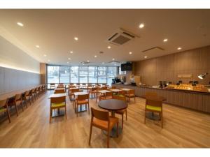 R&B Hotel Sendai Higashiguchi - Vacation STAY 39923v في سيندايْ: مطعم بطاولات وكراسي وكاونتر