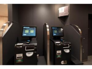 2 machines à deux atm avec des écrans sur un mur dans l'établissement R&B Hotel Sendai Higashiguchi - Vacation STAY 39923v, à Sendai