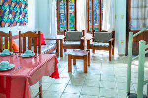 ein Esszimmer mit Tischen und Stühlen mit rotem Tischtuch in der Unterkunft Res Village do Bosque 16 in Porto Seguro