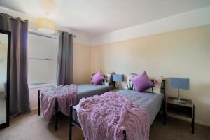 sypialnia z 2 łóżkami i fioletowymi kocami w obiekcie Virexxa Aylesbury Centre - Executive Suite - 2Bed Flat with Free Parking w mieście Aylesbury